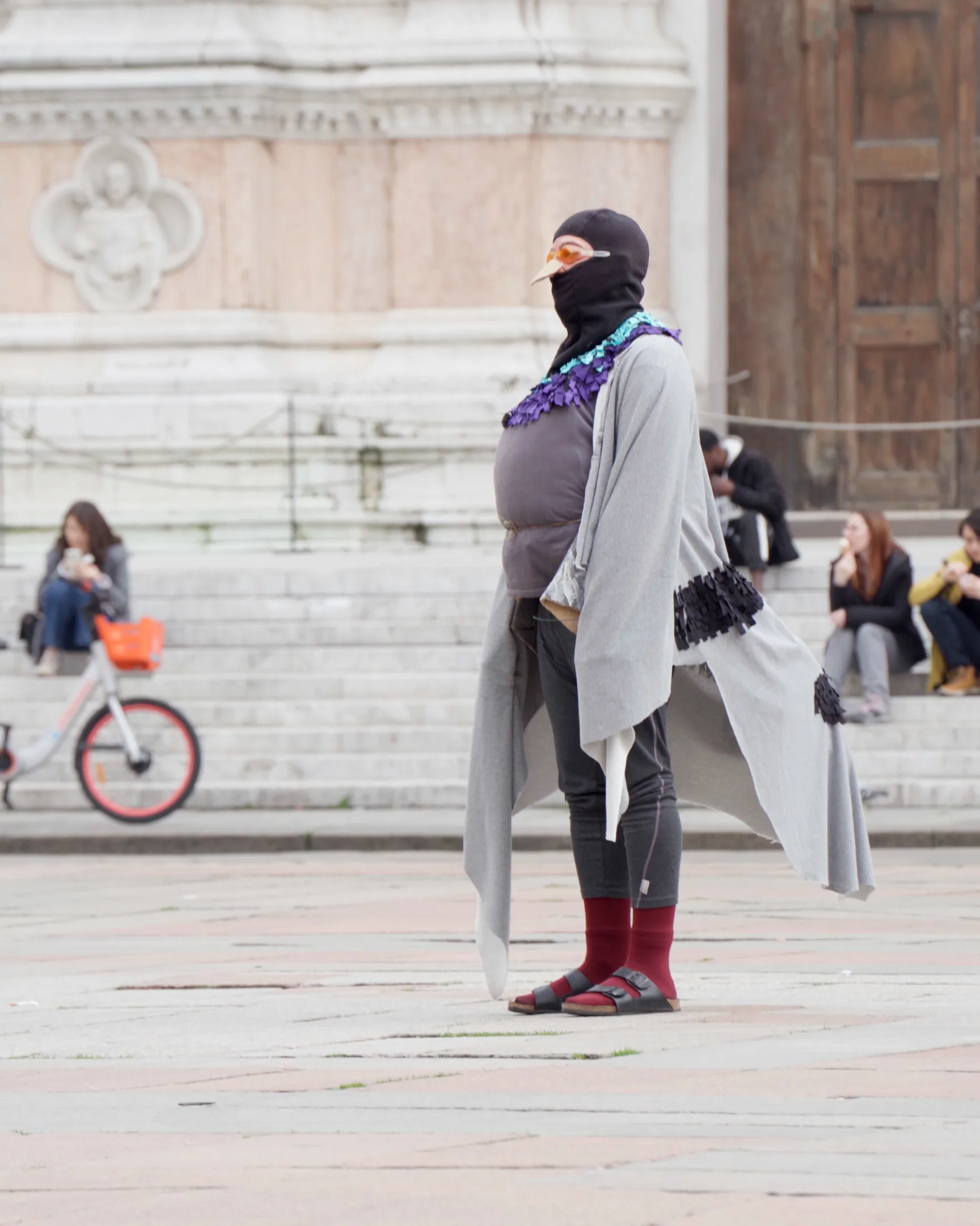 Figura travestita da piccione in piazza